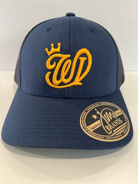 Navy trucker cap with a gold crowned W monogram in raised embroidery and a JM4 Brands Signature Crown sticker on the brim